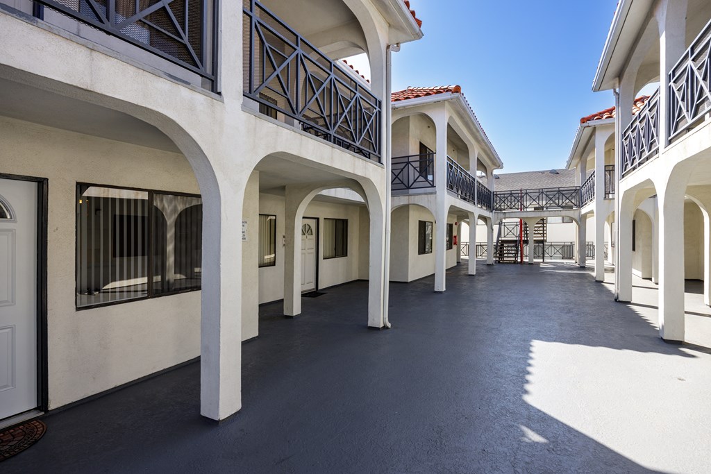 A long balcony with white columns and black railings.
