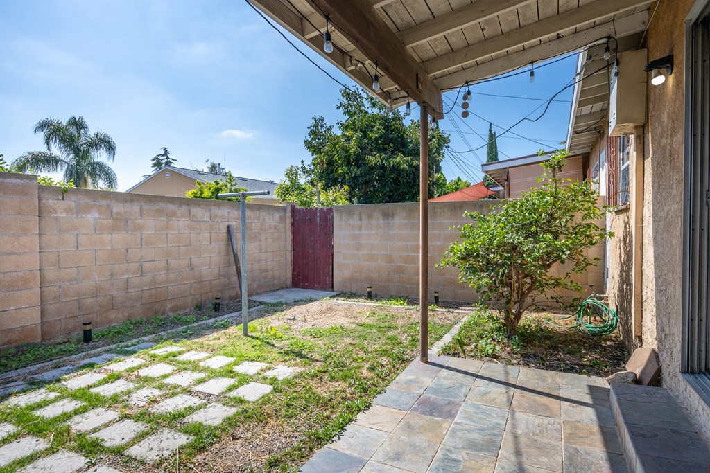 a backyard with a brick wall and a gate