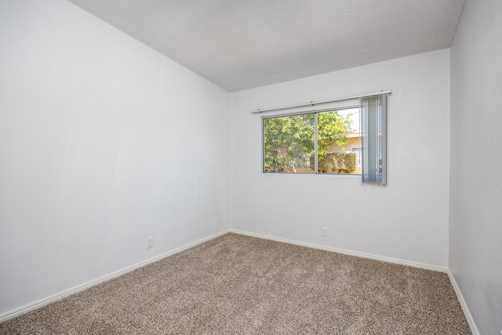 an empty room with white walls and a window