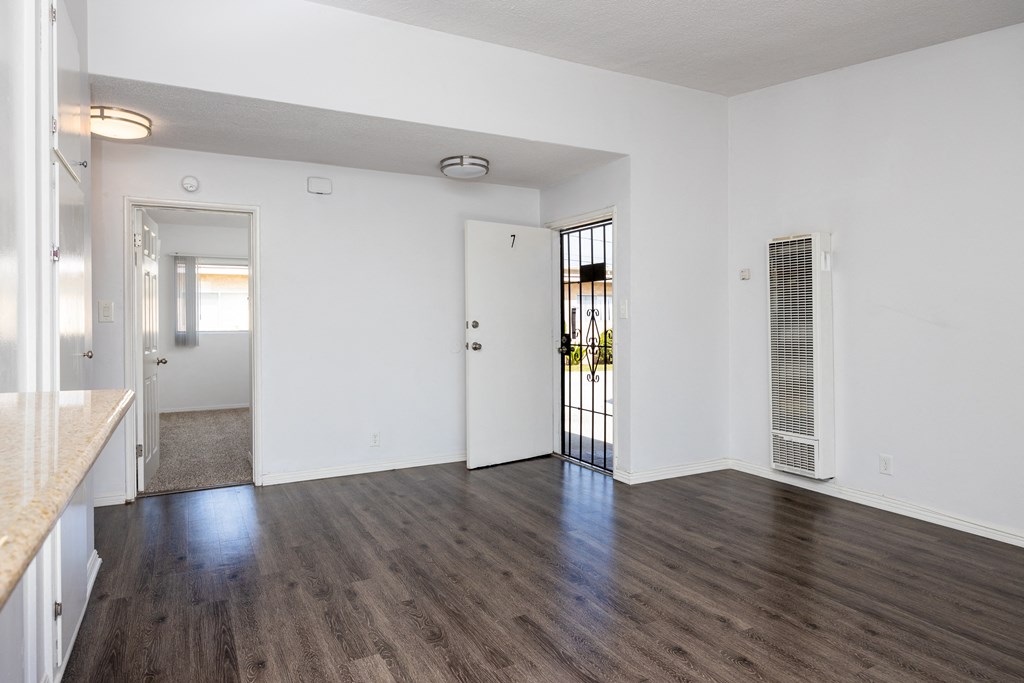 an empty living room with white walls and wood flooring