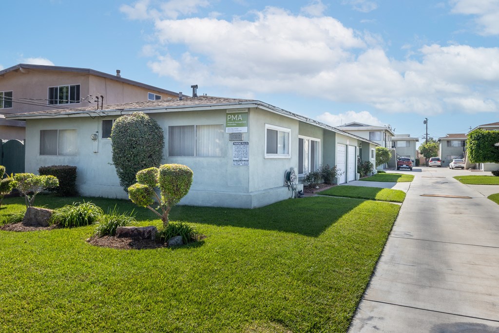 a white house with a sidewalk and a lawn in front of it