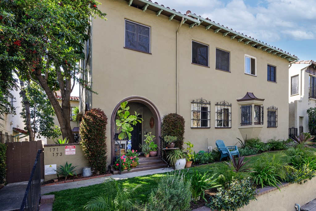 a house with an arched doorway and a garden outside of it
