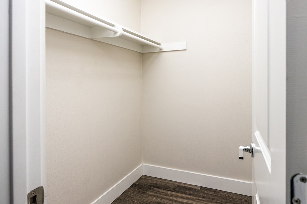 a small closet in a white room with a white door
