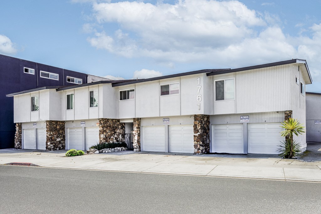 a white building with white garage doors and a blue sky