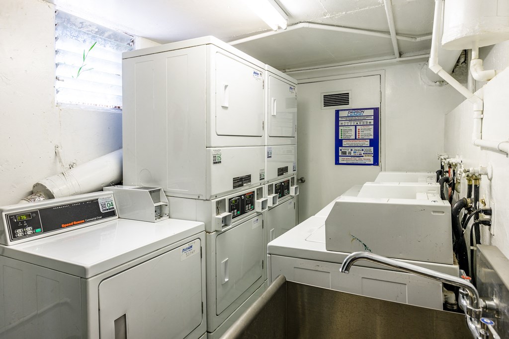 a laundry room with white appliances and a sink