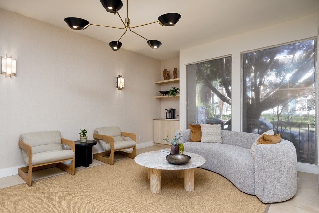 a living room with a couch and two chairs and a large window