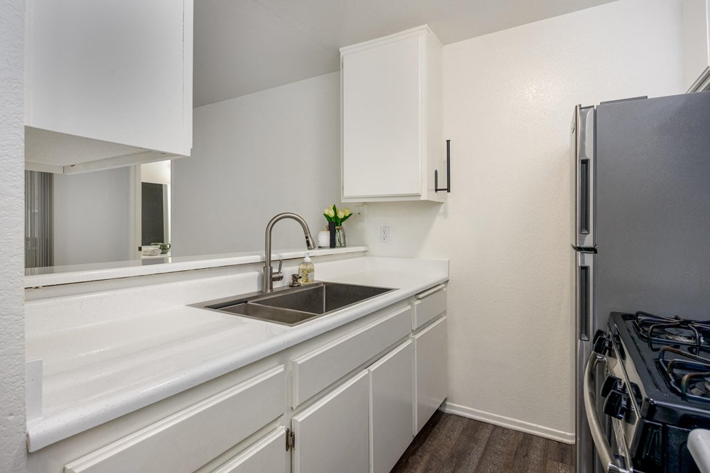 A kitchen with white cabinets and a black stove.