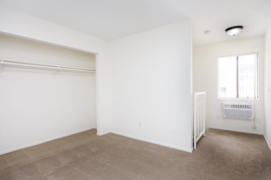an empty room with a radiator and a window in a home with white walls