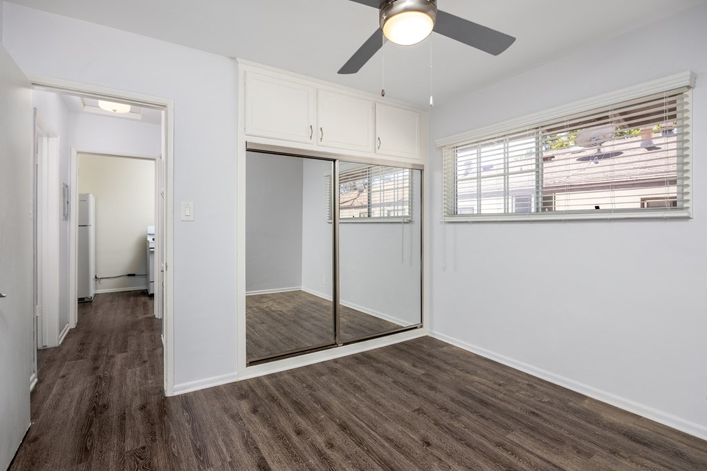 an empty room with a window and a ceiling fan