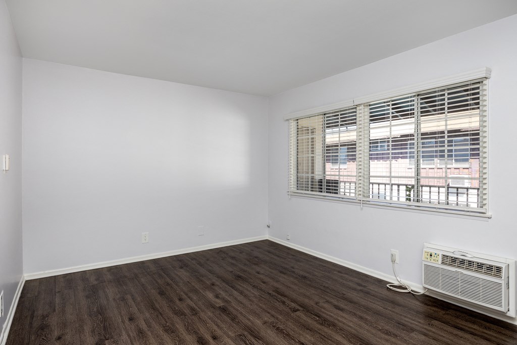 an empty living room with white walls and a window