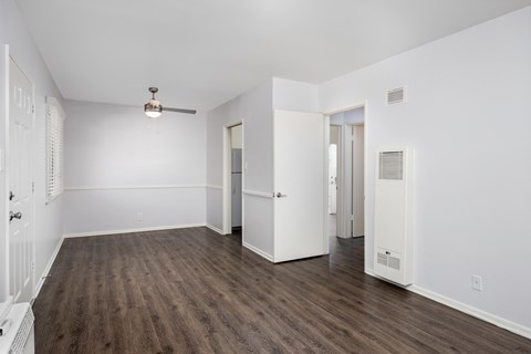 an empty living room with white walls and wood flooring