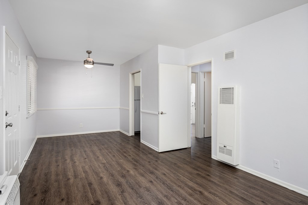 an empty living room with white walls and wood flooring