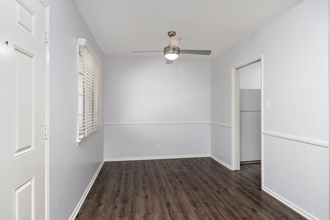 an empty bedroom with white walls and wood flooring and a closet