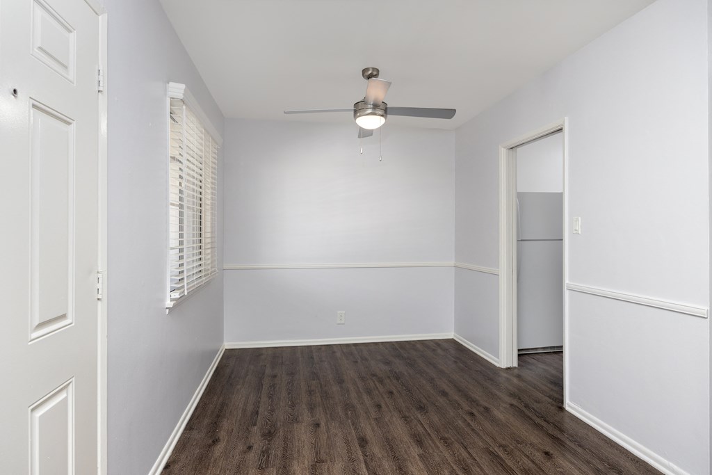 an empty bedroom with white walls and wood flooring and a closet