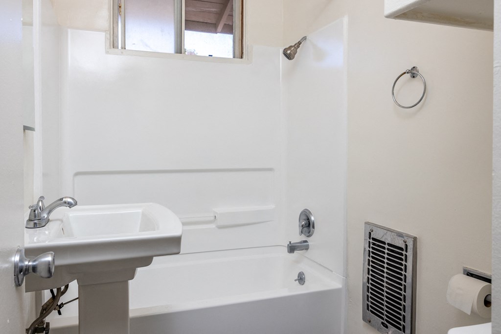 a bathroom with a sink and a tub and a window