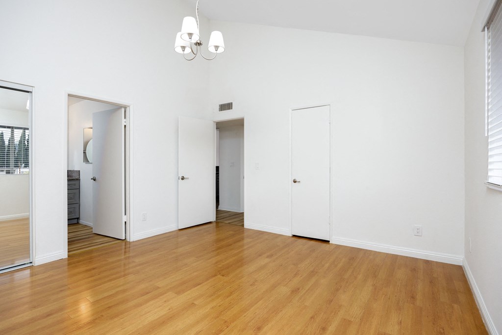 an empty living room with white walls and a wood floor