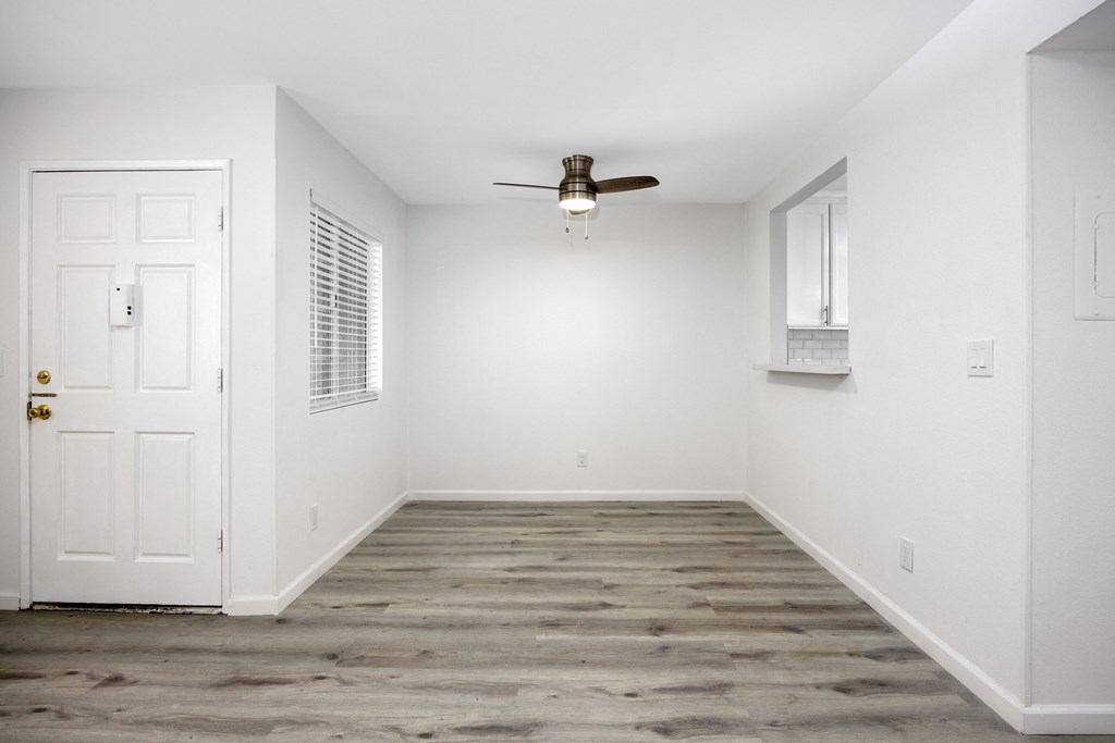 an empty room with white walls and a ceiling fan
