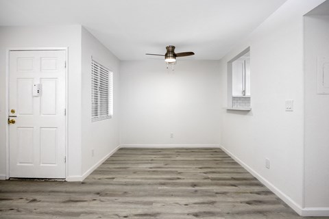 an empty room with white walls and a ceiling fan