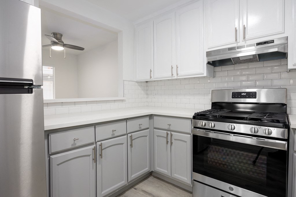a kitchen with white cabinets and stainless steel appliances