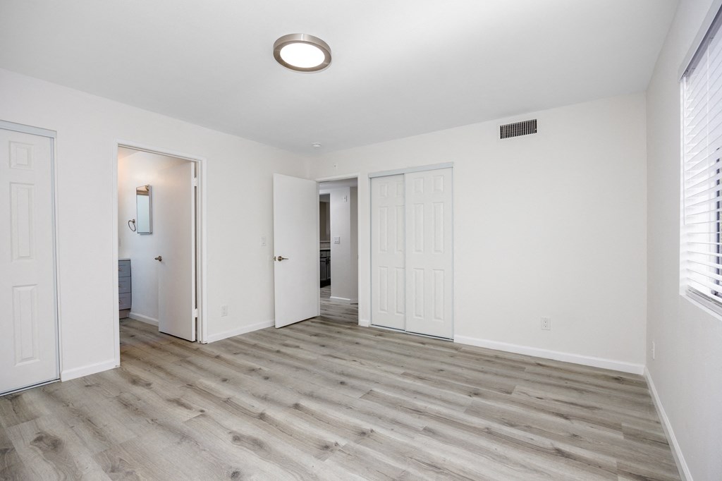 an empty living room with white walls and wood flooring