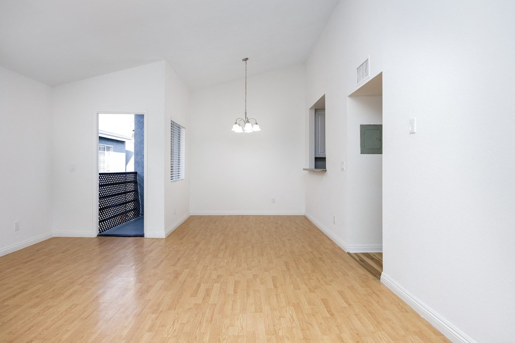 an empty living room with wood floors and white walls