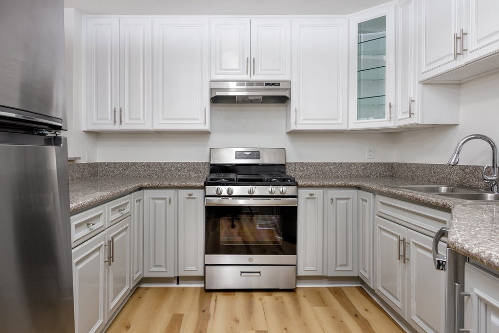 a kitchen with white cabinets and stainless steel appliances