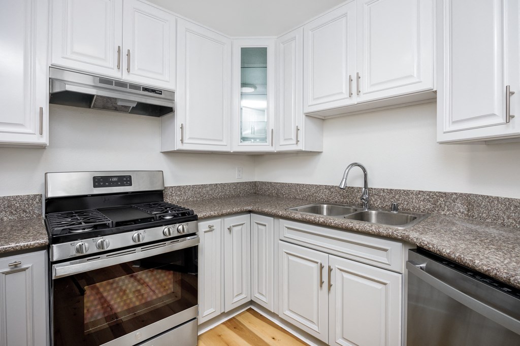 a kitchen with white cabinets and stainless steel appliances