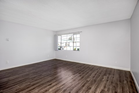 A room with wooden flooring and a window.