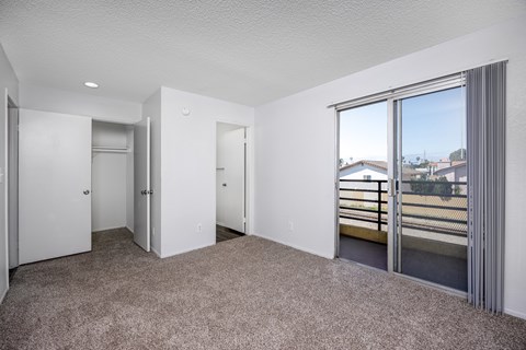 A spacious room with a view of the outside through a sliding glass door.