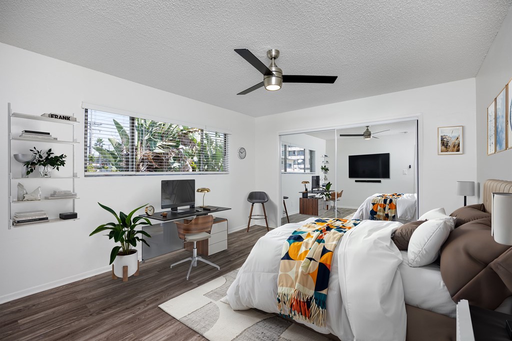 A bedroom with a bed, desk, and chair.