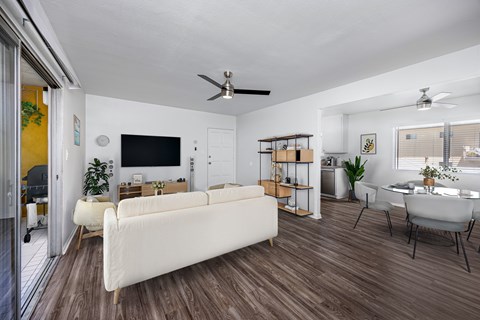 A living room with a white couch and a television on the wall.