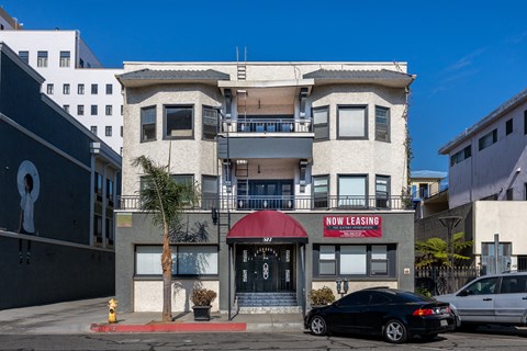 a building with a red awning and a car parked in front of it