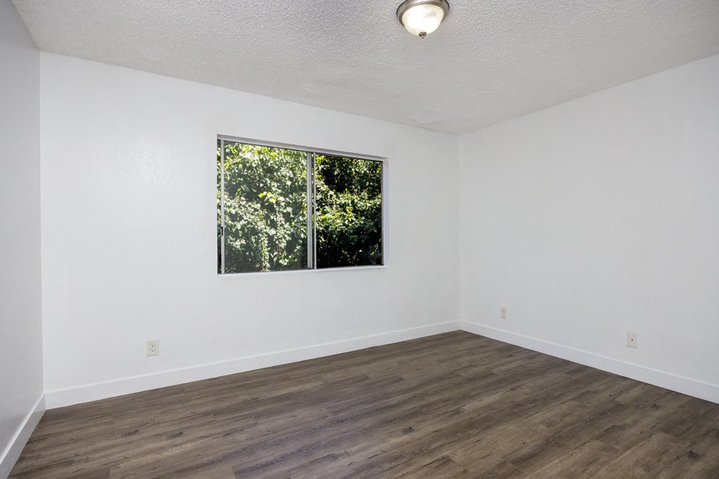an empty room with white walls and a window