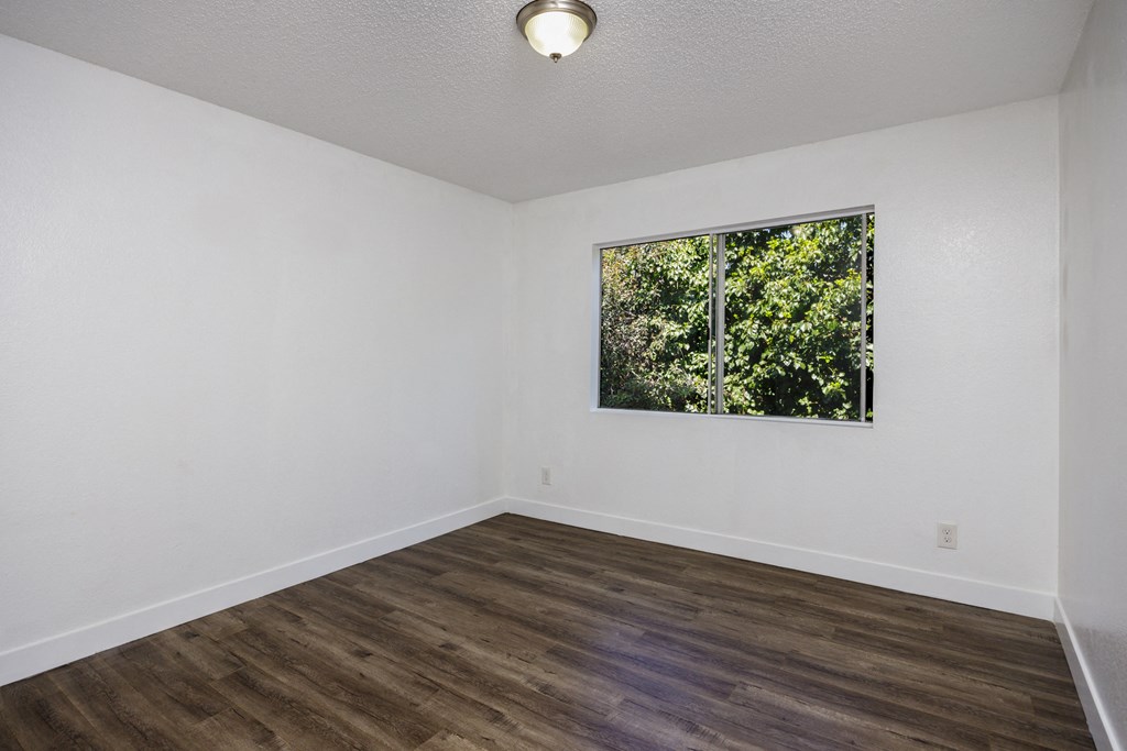an empty room with white walls and a window