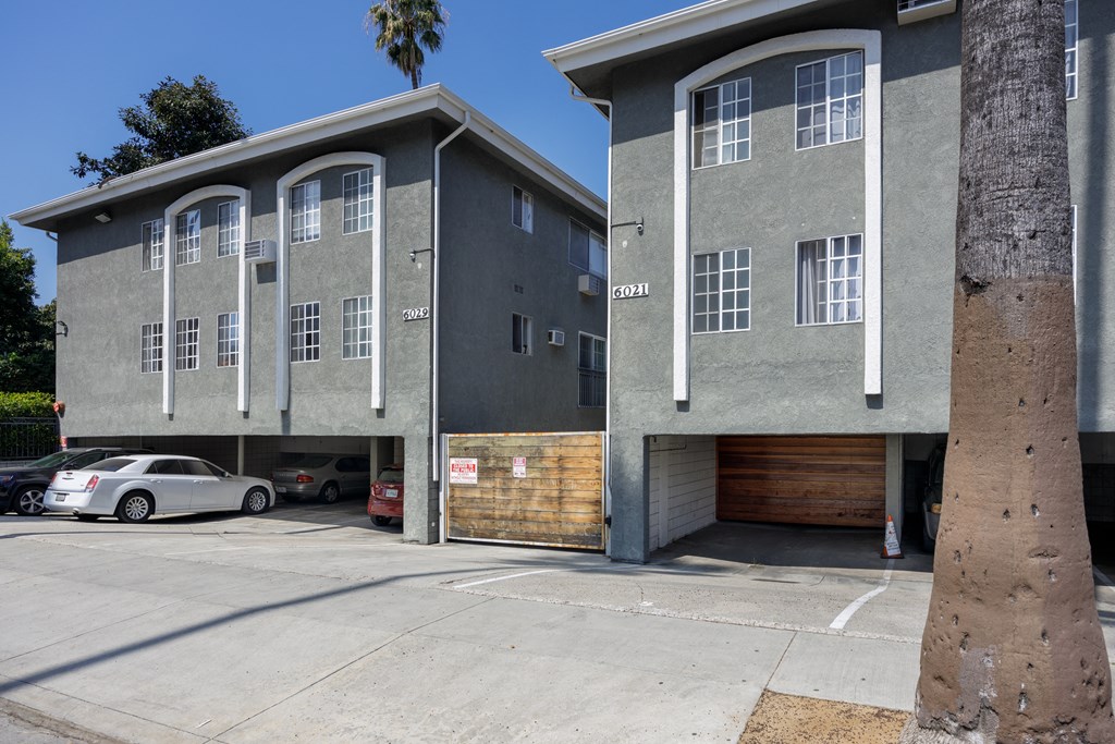 an apartment building with a garage and a parking lot