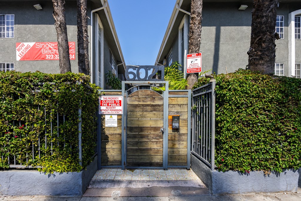 a gate with a wooden door in front of a building