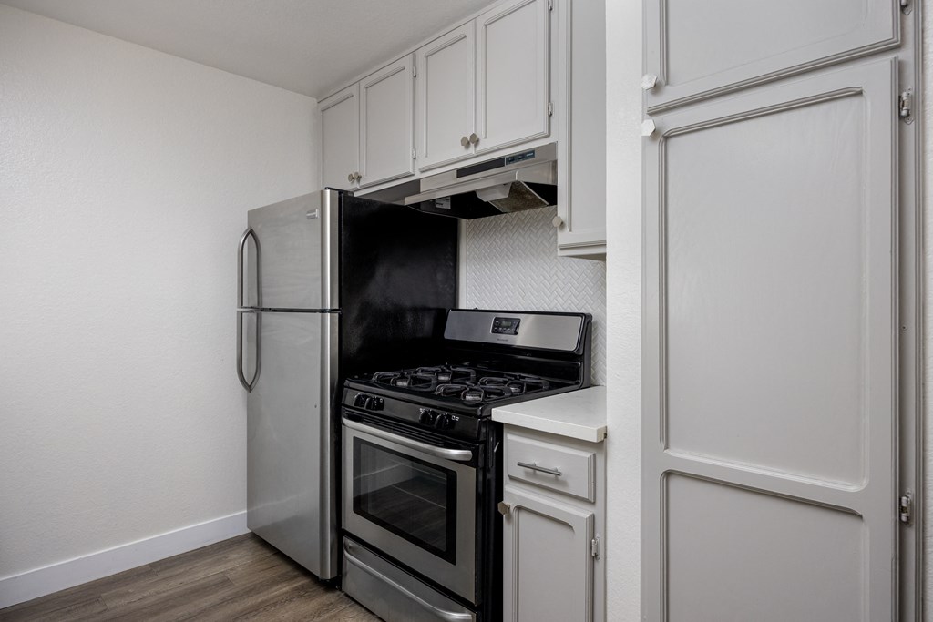 a kitchen with stainless steel appliances and white cabinets