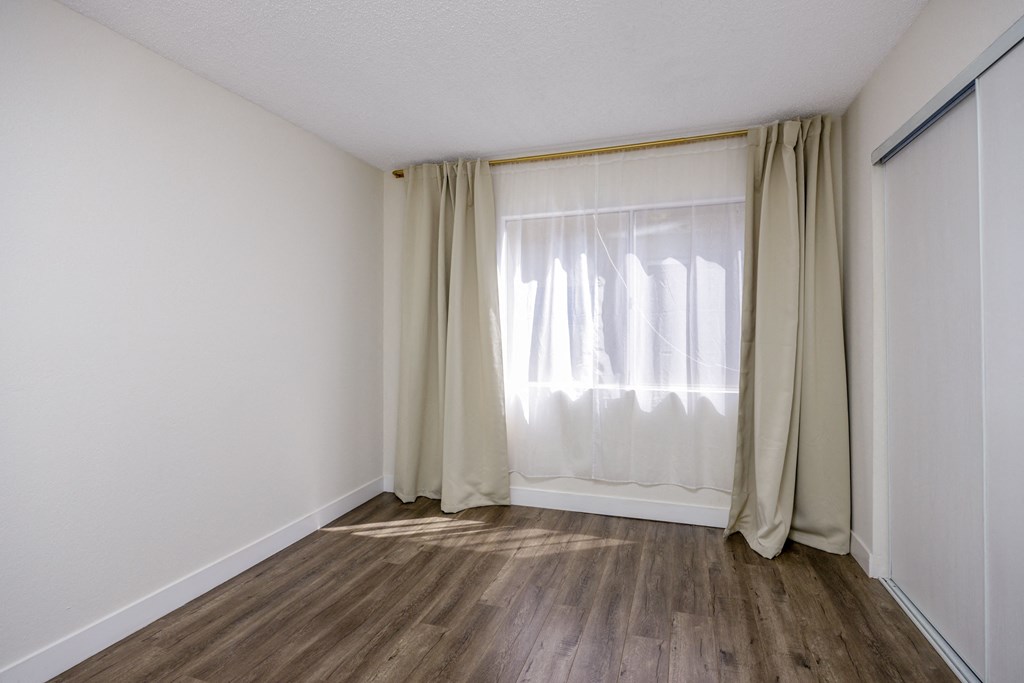 an empty room with curtains and a window