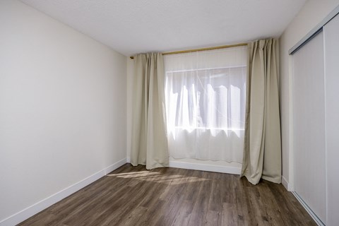 an empty room with curtains and a window