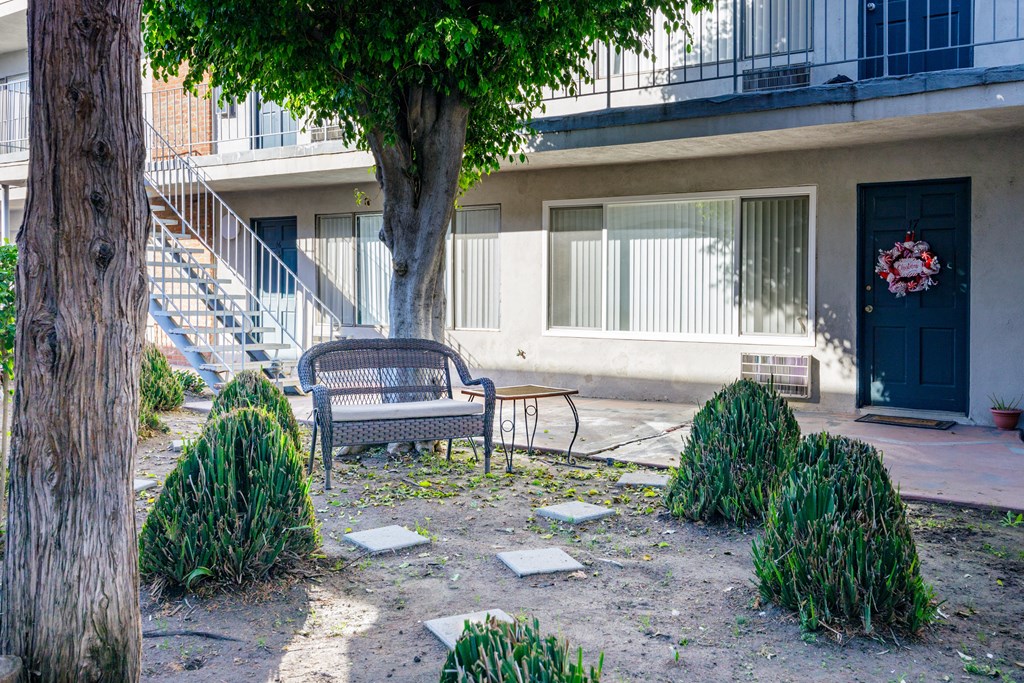 a bench sitting under a tree in front of a building