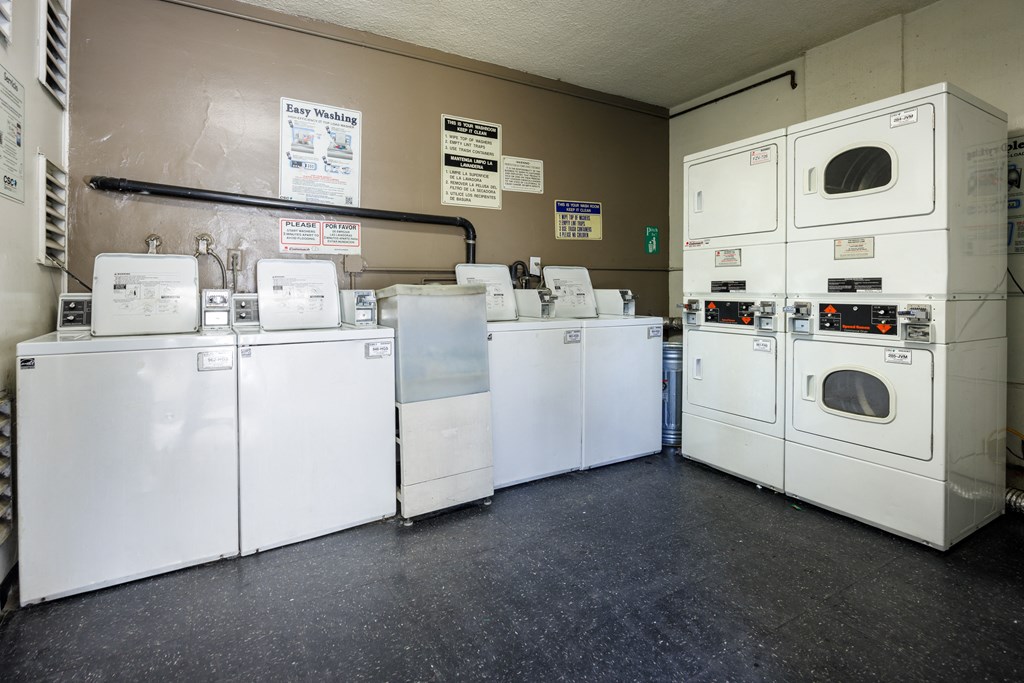 a row of washers and dryers in a utility room
