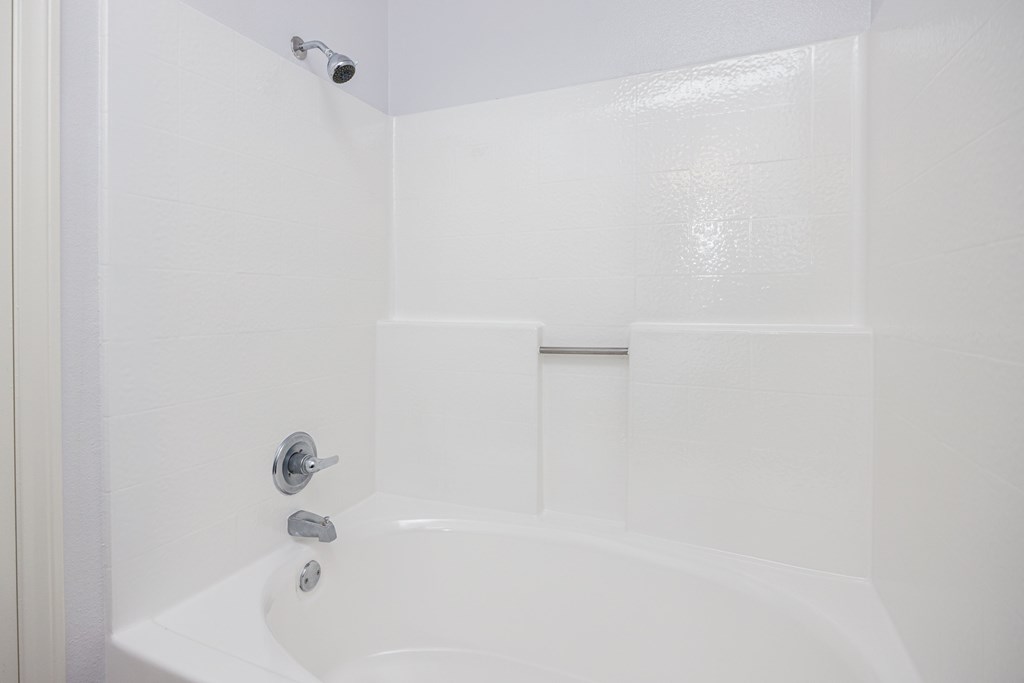 a white bathroom with a shower and a sink
