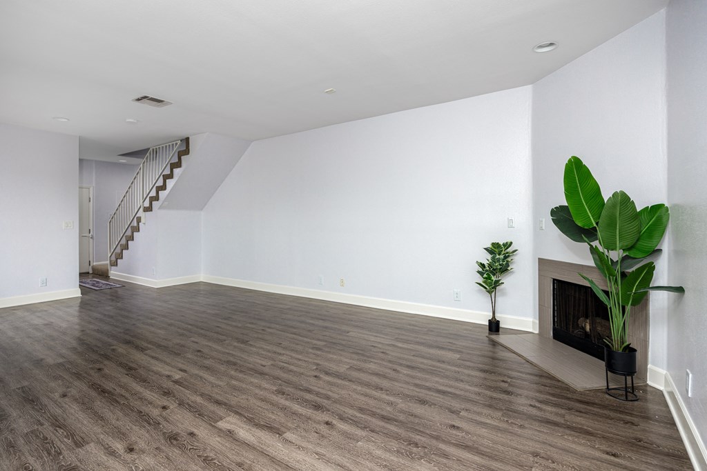 a living room with white walls and a fireplace and a green plant