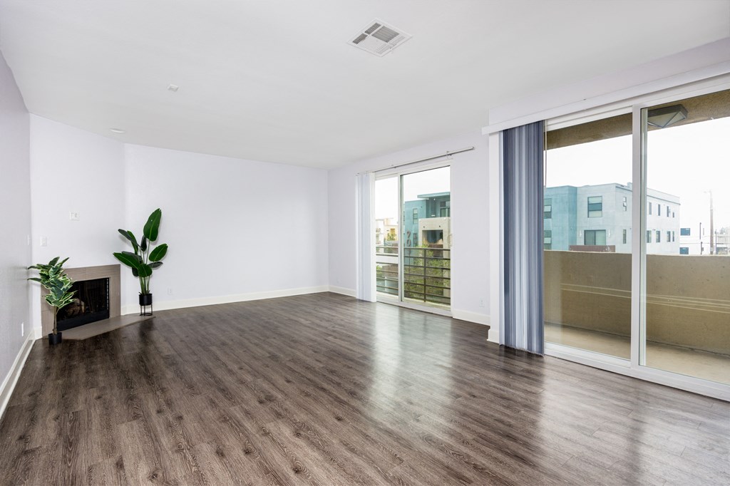 a living room with white walls and wood floors and a fireplace