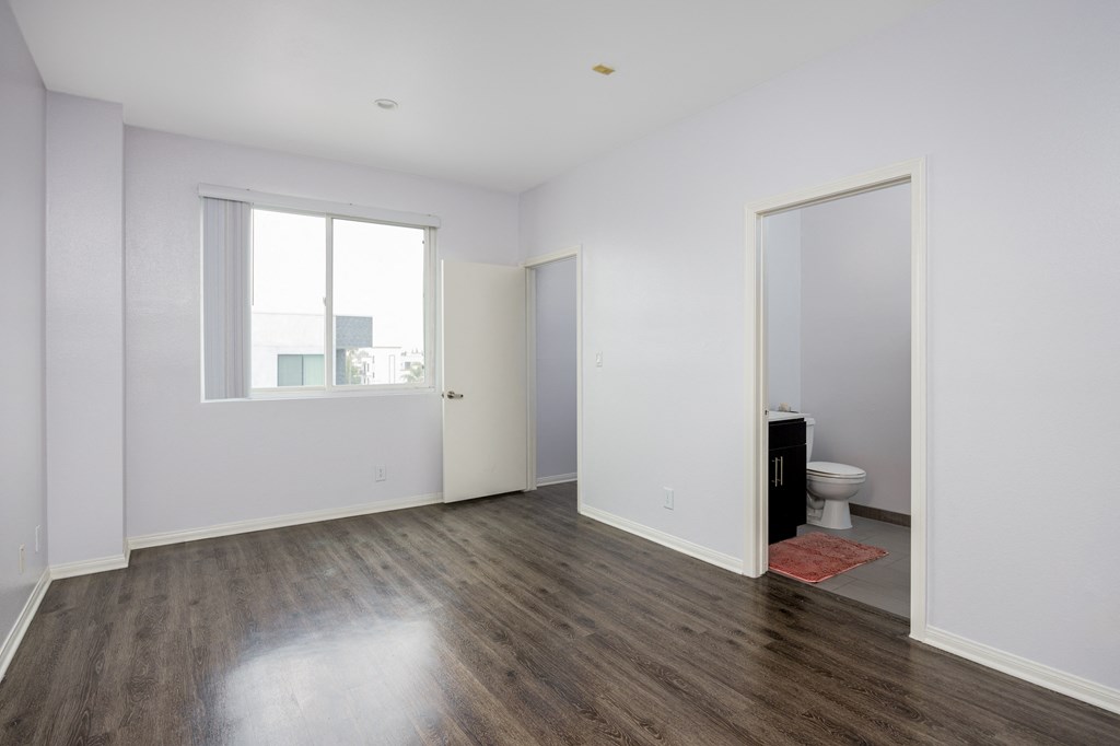 a living room with white walls and a door to a bathroom