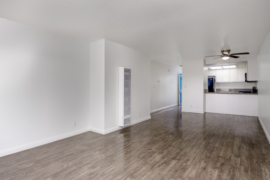 an empty living room with white walls and wood flooring