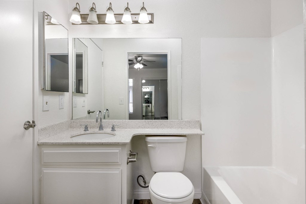 a bathroom with a sink toilet and a mirror