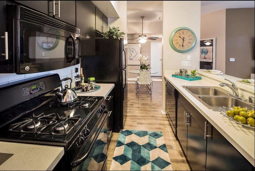 a kitchen with a stove top oven next to a sink