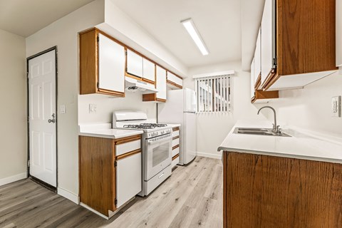 A kitchen with wooden cabinets and white appliances.