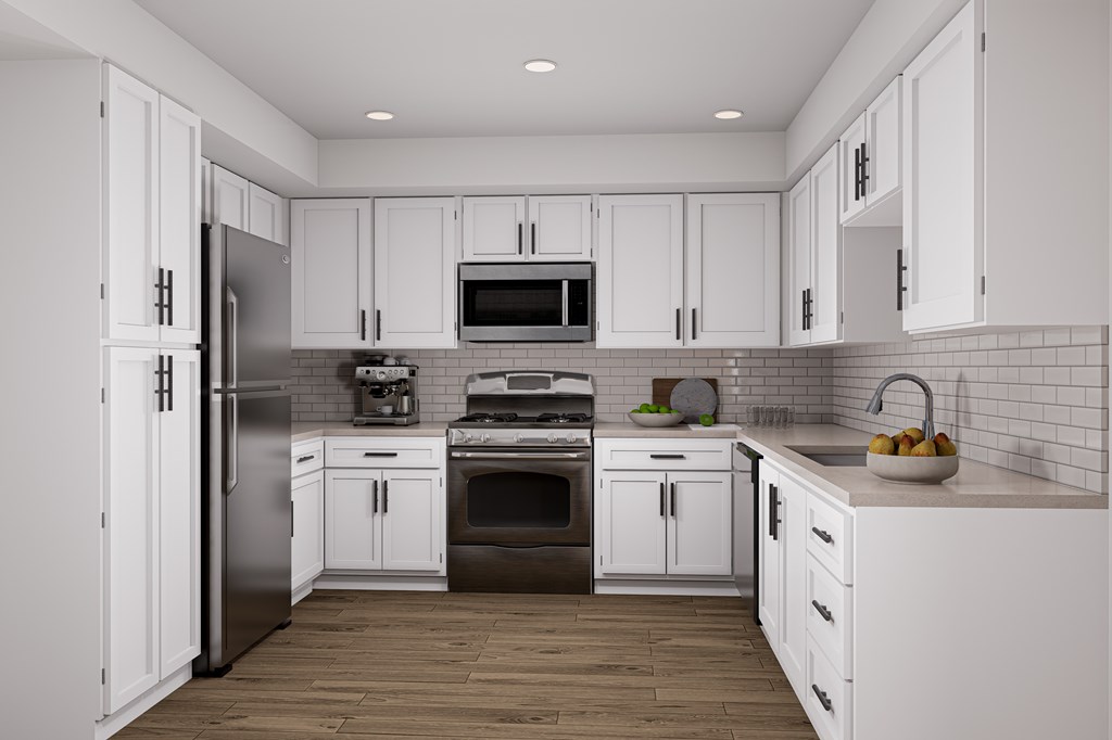 A modern kitchen with white cabinets and stainless steel appliances.